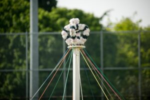 The top of a May Pole decorated with a crown of flowers